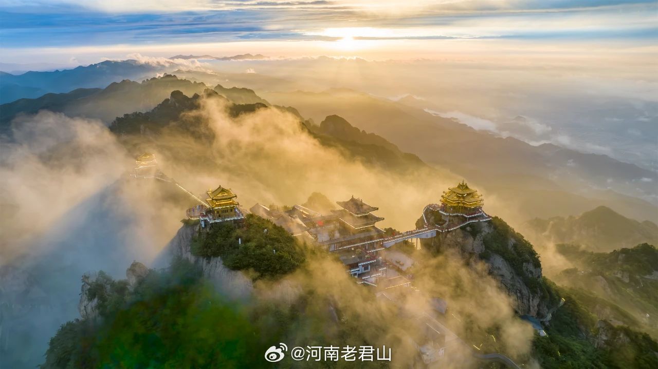 当阳光穿透云层，金顶道观群在翻腾的云雾中若隐若现。山风轻拂、云涛漫卷，此情此景便