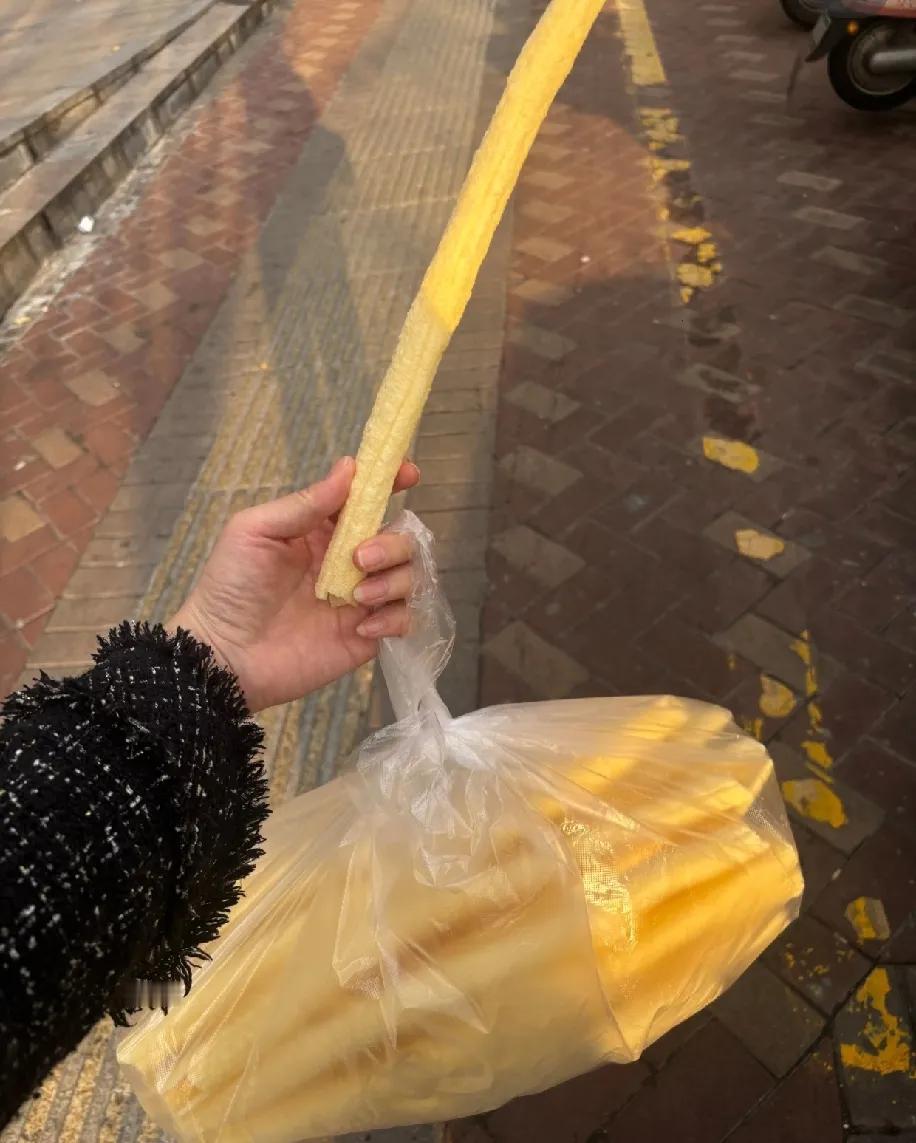 刚在路边攥着这袋“巨型江米条”（也可能叫米通？），手指头都被撑得蜷不拢——这玩意