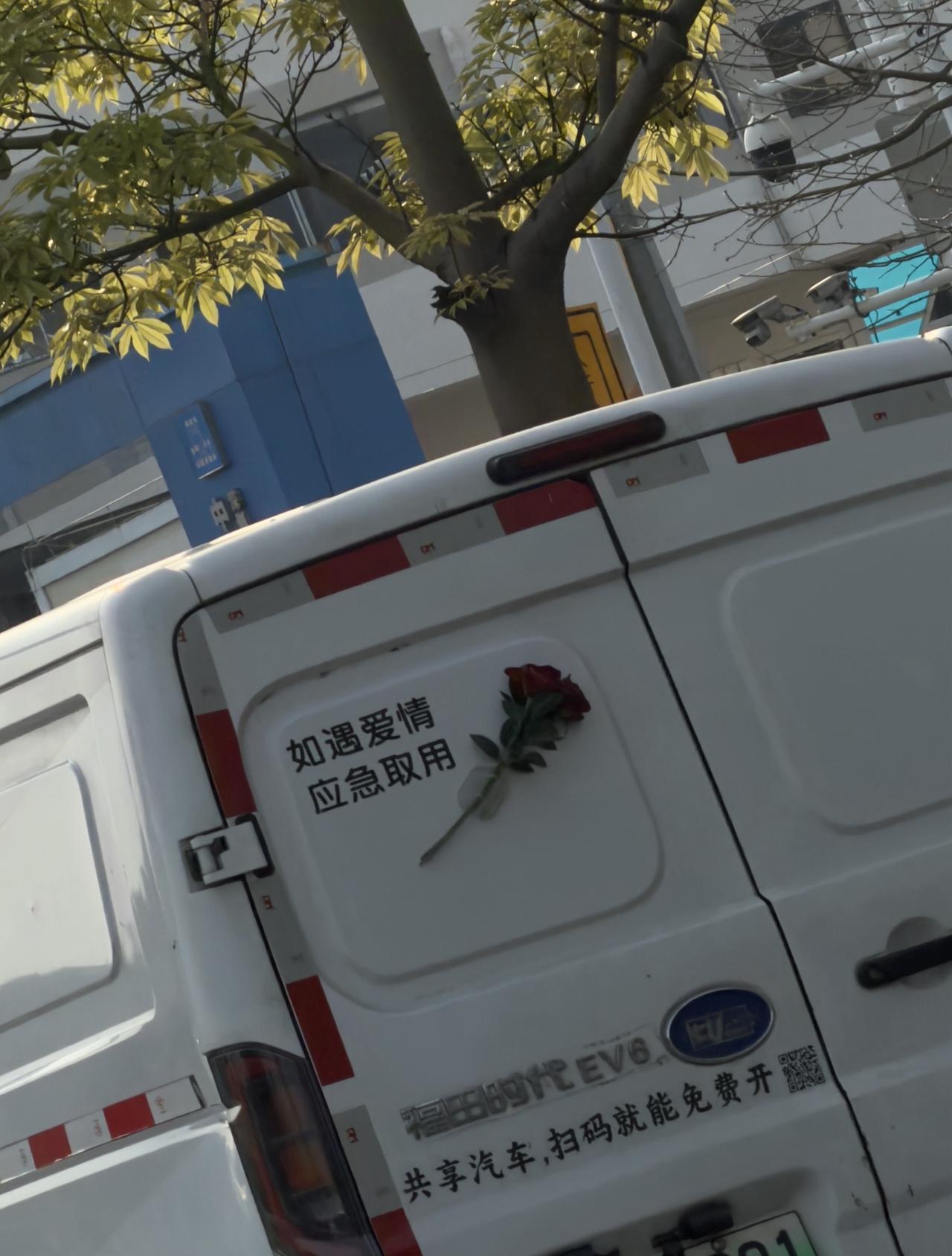 路上遇到一辆让人相信爱情的车，贴了一支玫瑰花，并配文「如遇爱情 应急取用」。
