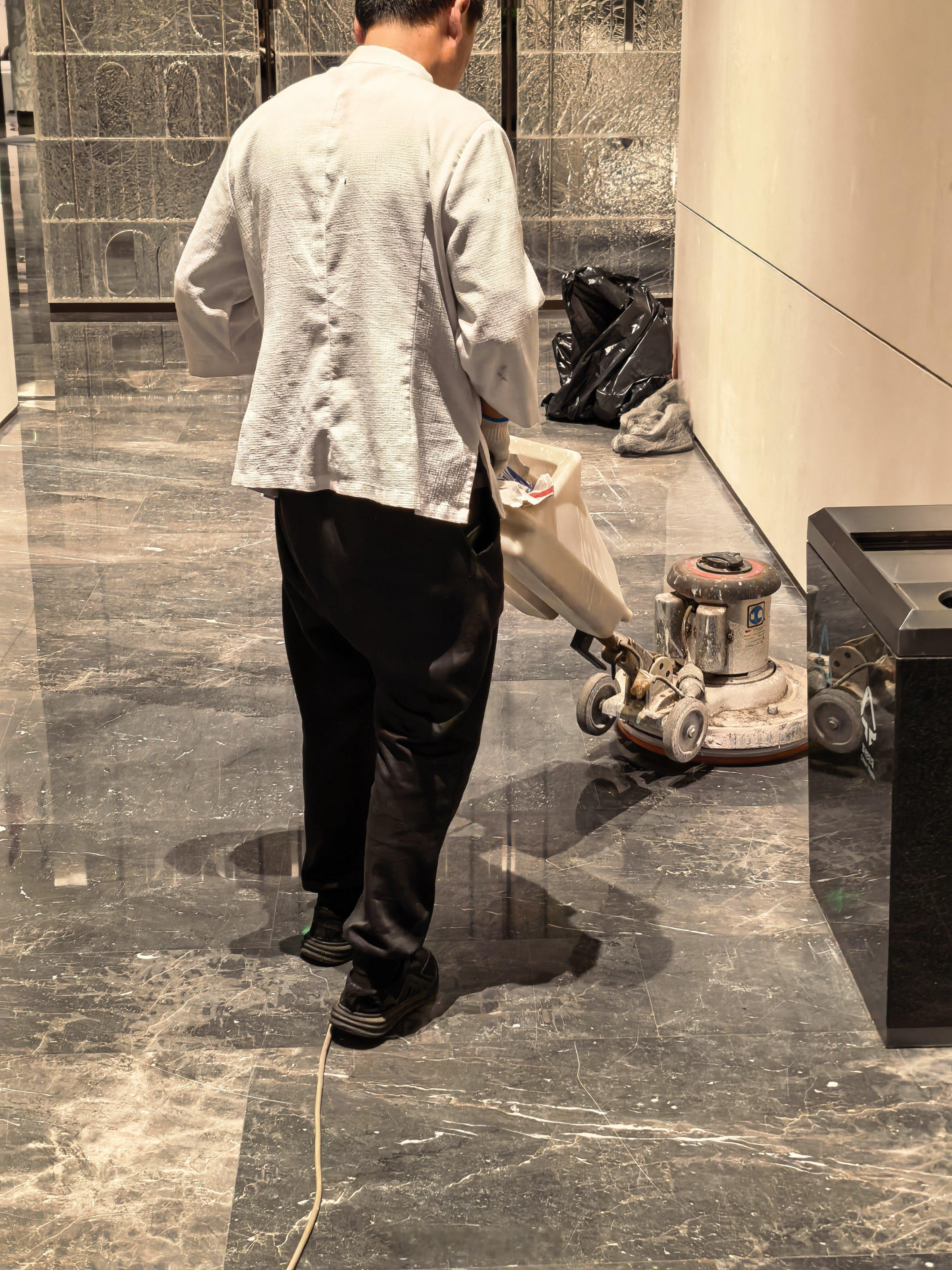 酒店工作人员在做大理石地面的保养。突然觉得扫地机器人还可以增加一个功能：大理石抛