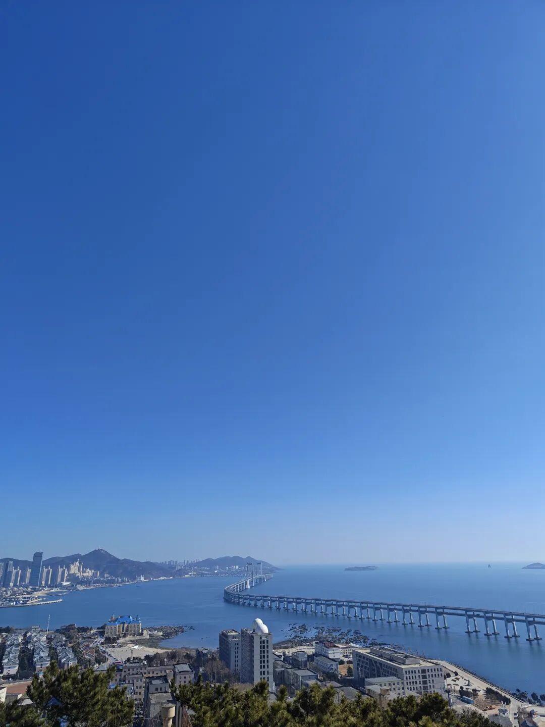 阳光毫无遮挡地铺洒下来，落在海面，让粼粼波光与晴空相映；落在跨海大桥上，把桥身的