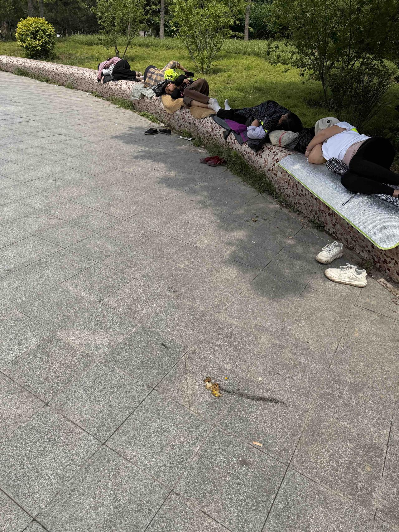 几个工人在长椅上睡觉，鞋子散落在地。大夏天还是很辛苦的！夜里的建筑工地 打工小憩