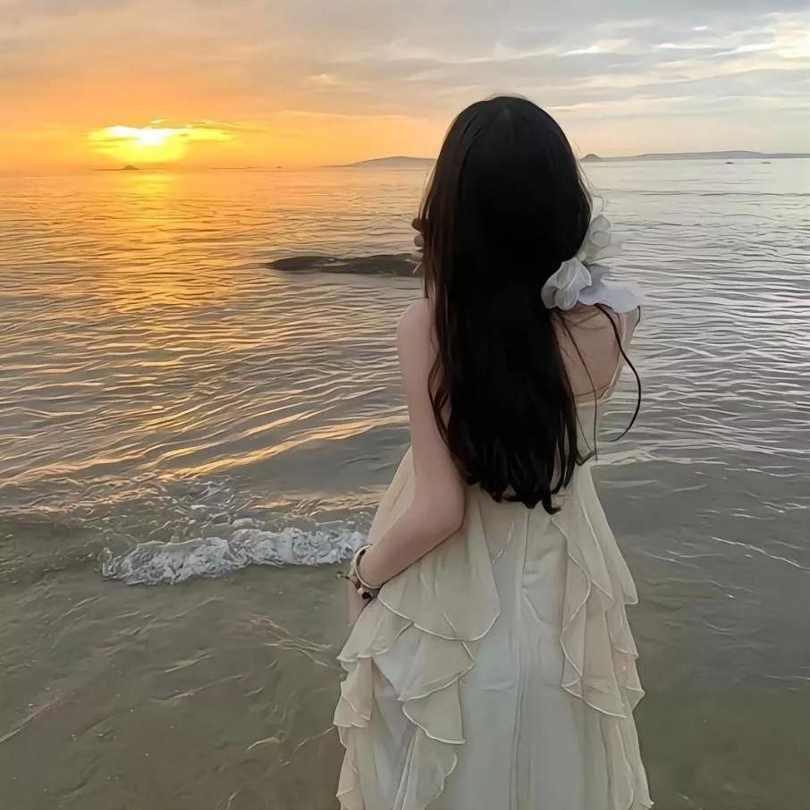 温柔的海边日落，少女裙摆飞扬海边度假少女 日落晚霞照海滩 海边日落景 裙摆上的阳