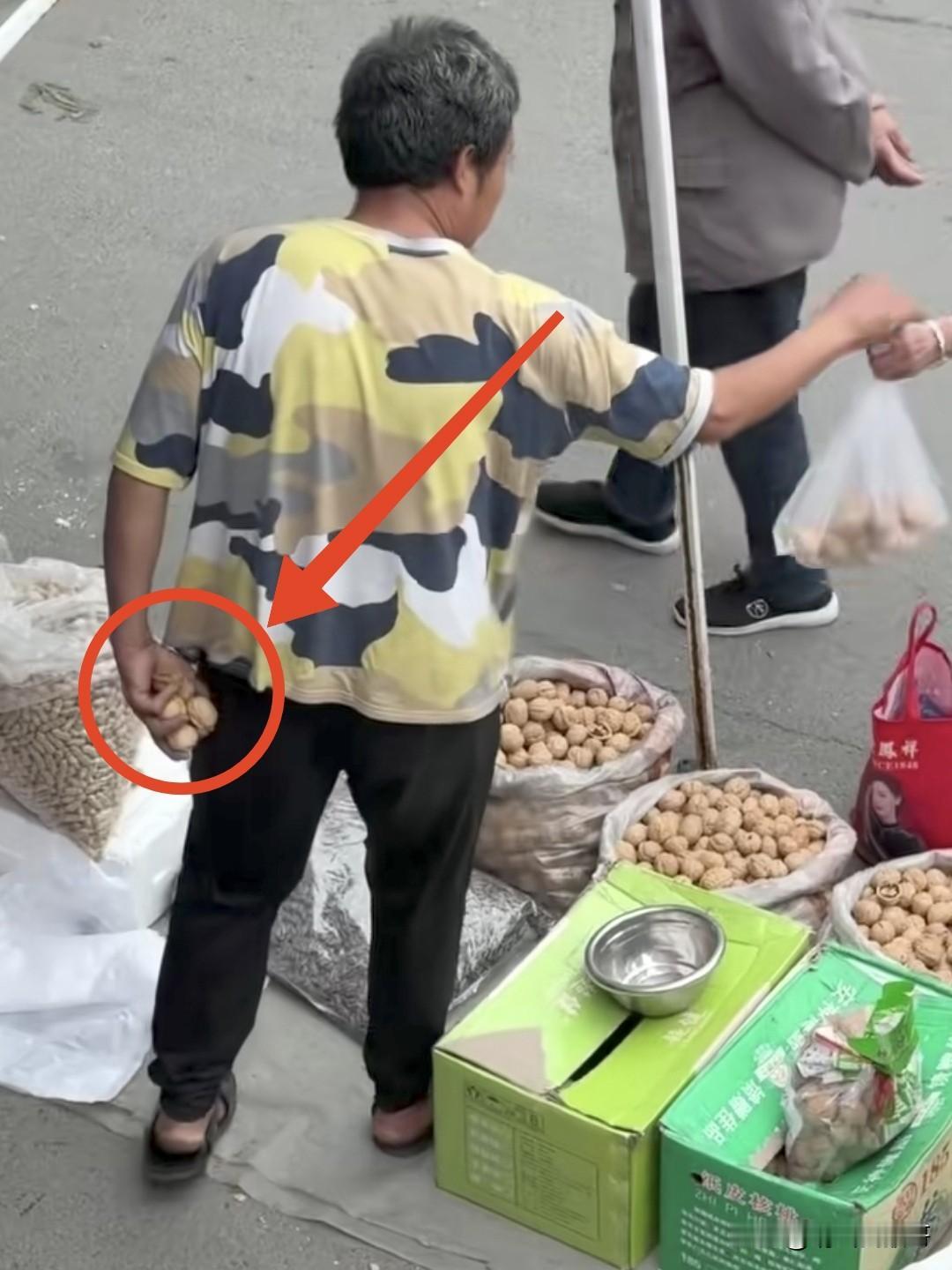 这样做生意当真可恶，别人花真金白银来买核桃，这摊主倒好，一边假意让顾客自己挑选，