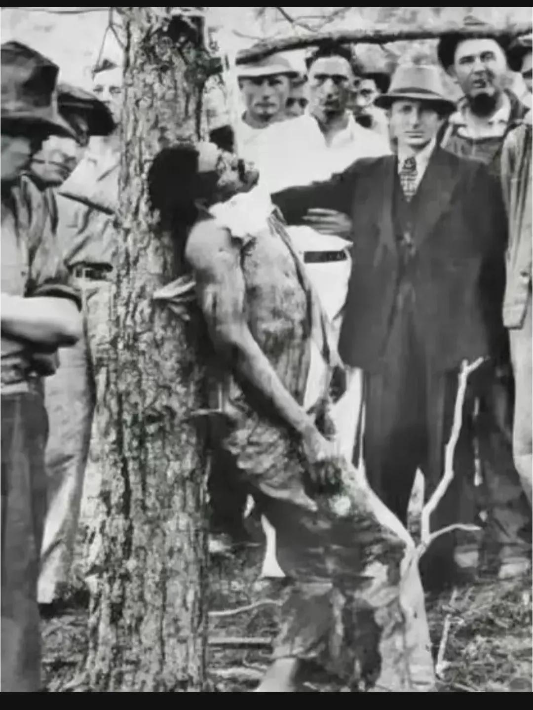 1935年，美国街头，一名被“私刑”处决的非洲裔男子，照片中的他歪着脑袋，被吊在