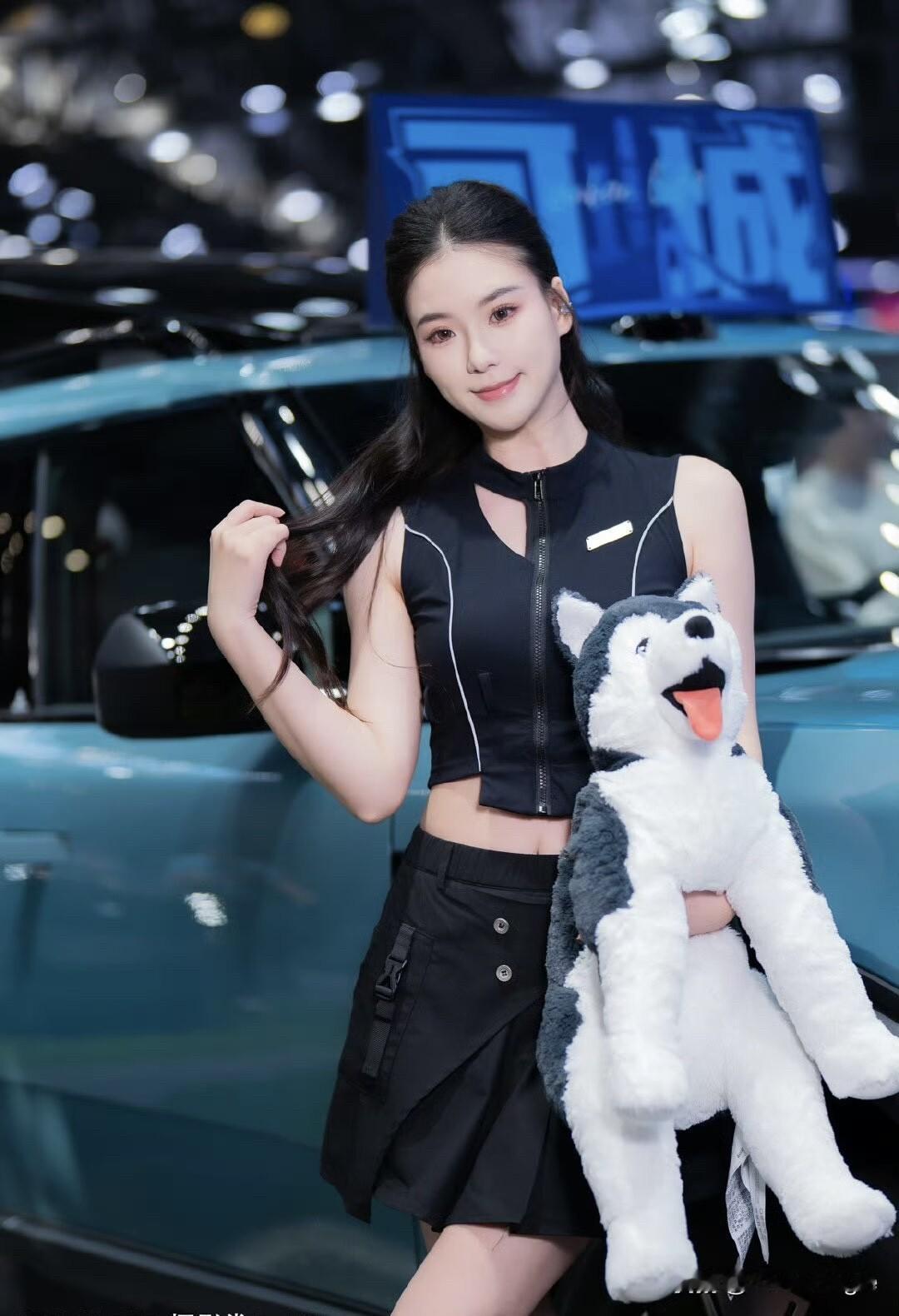 车展中美人笑，狗儿伴身旁。