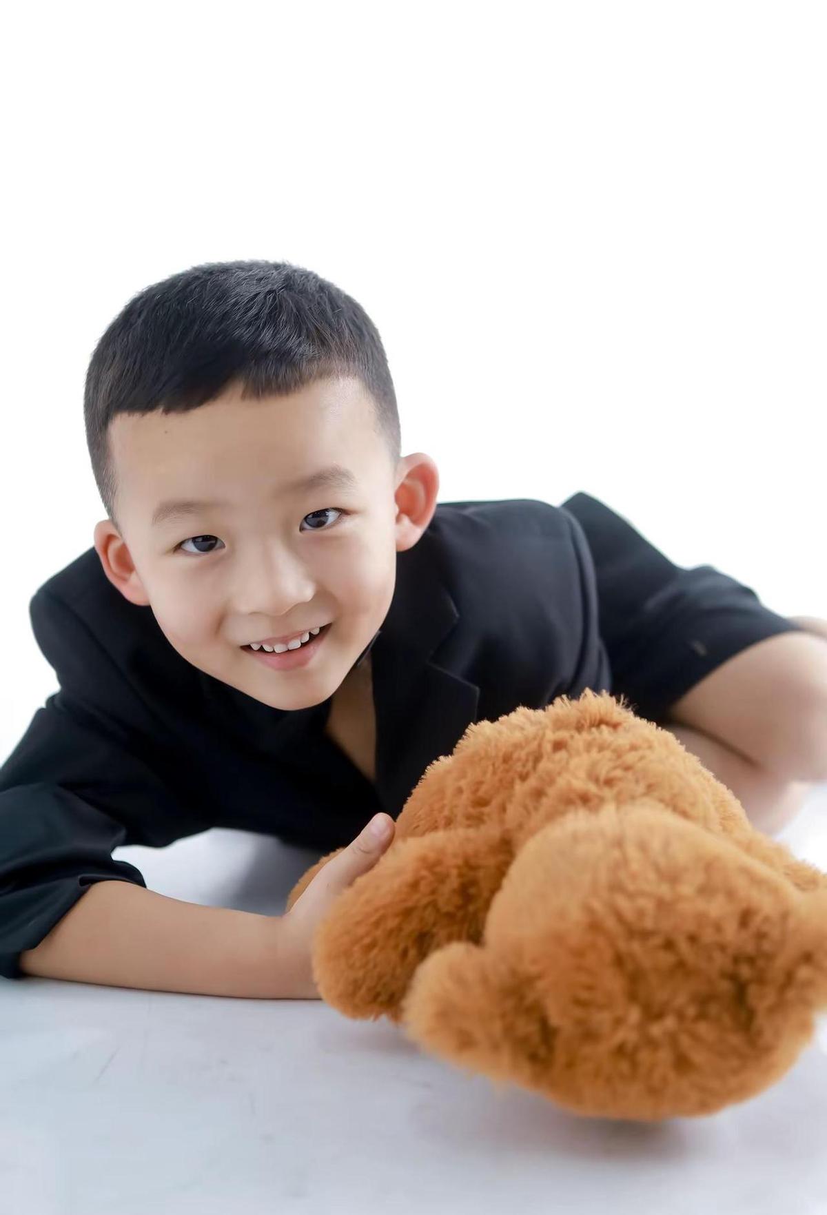 男孩穿着帅气，站得笔挺，笑容灿烂。
这画面太熟悉了，谁家的小帅哥不是这样？
看着