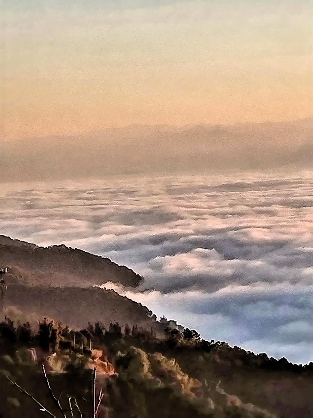 云海之上，山峦若隐若现，宛如仙境一般。那些被云海半掩的山峦，好似在和游人玩捉迷藏