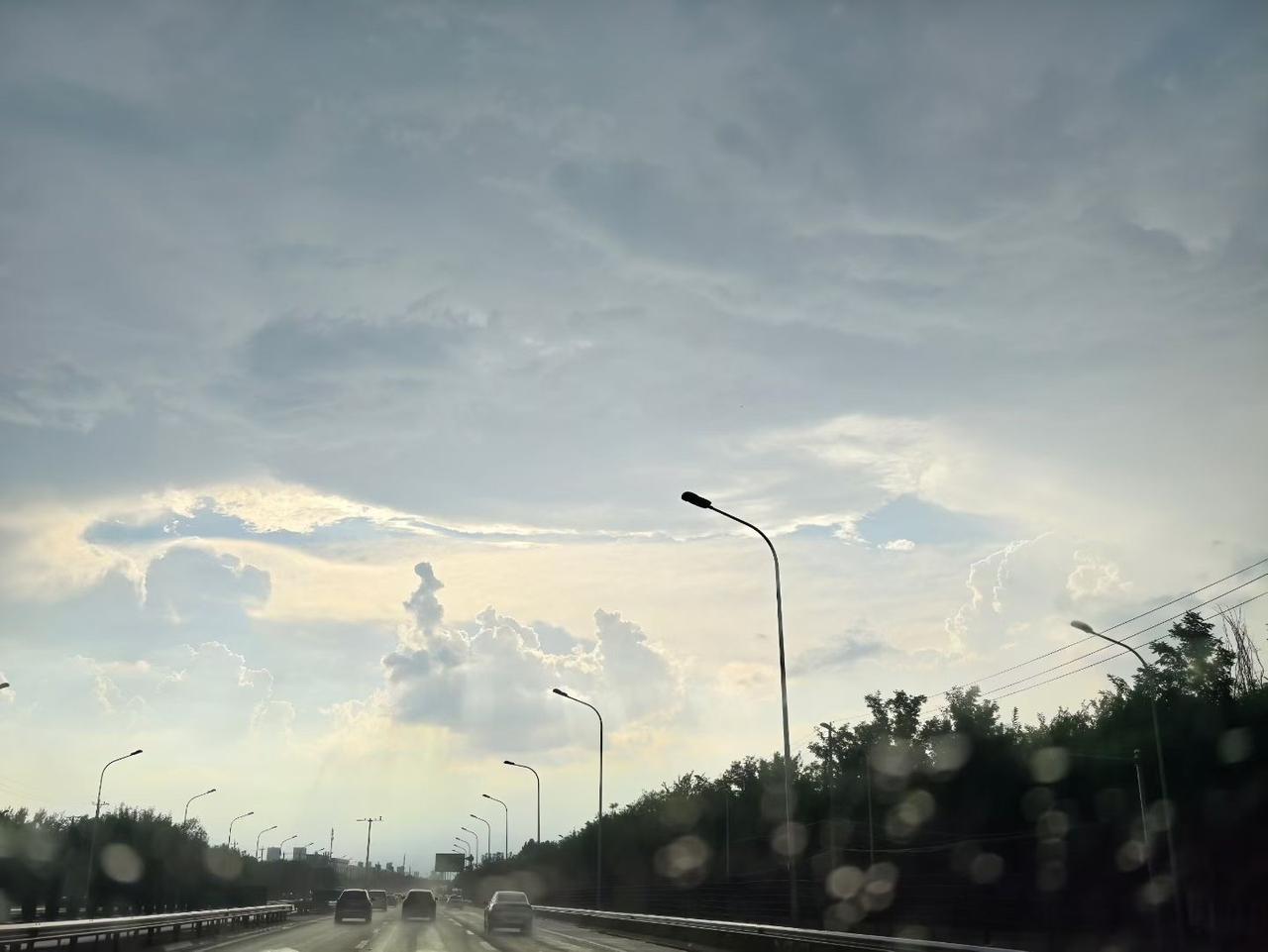 路上云朵像棉花糖，夕阳下好美。天空云朵照片 天空云朵景 城市傍晚云彩 淡黄色云朵