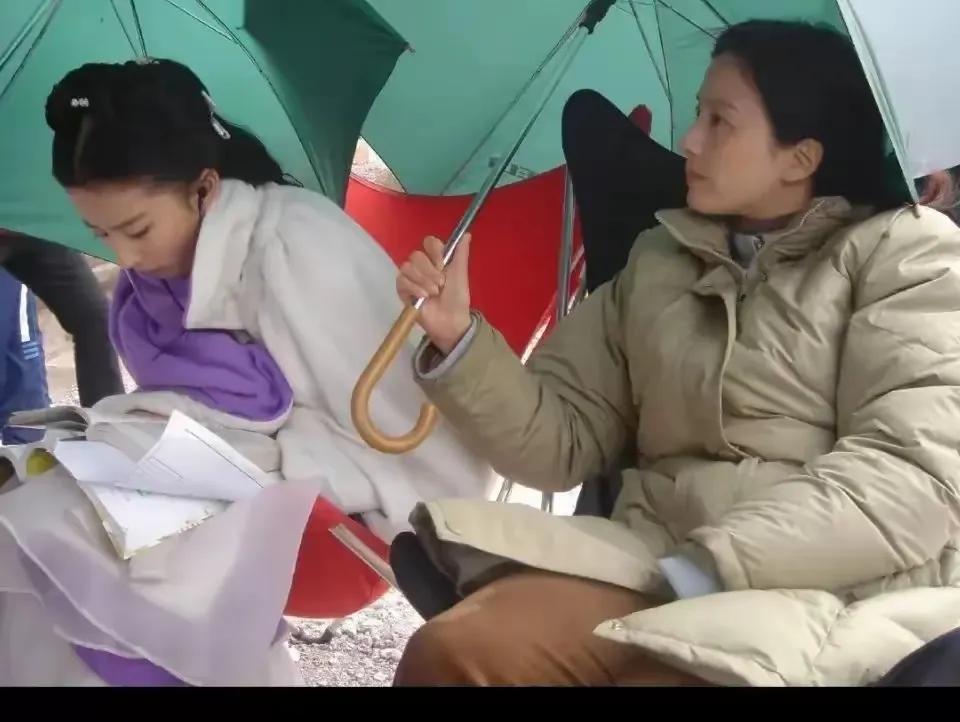 女儿认真看剧本，妈妈在一旁神情专注帮忙撑伞！都说儿行千里母担忧，其实也可以不担忧