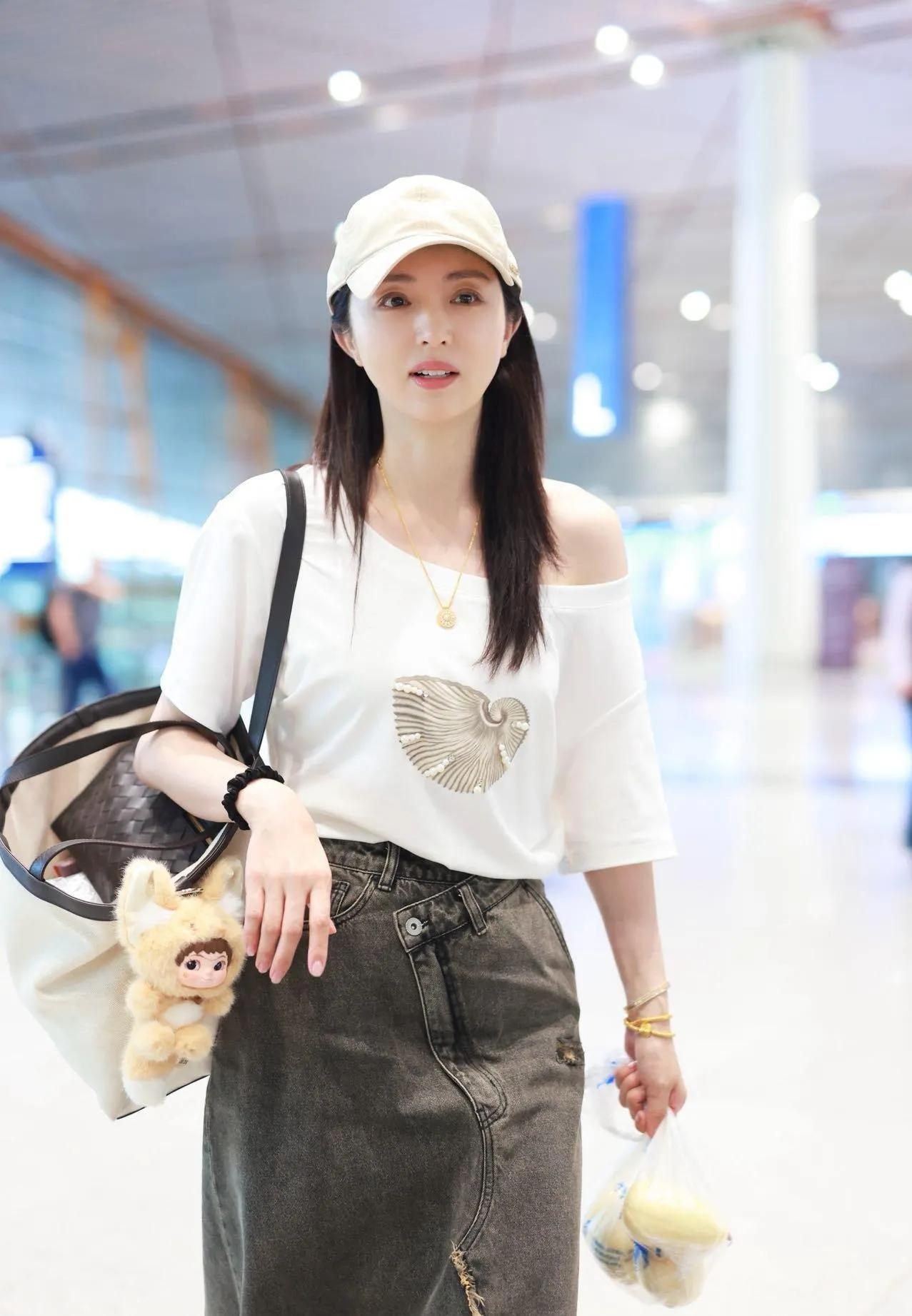 董璇机场私服太会搭💙
斜露肩白T恤+做旧开叉牛仔半裙
慵懒随性又温柔减龄
棒球