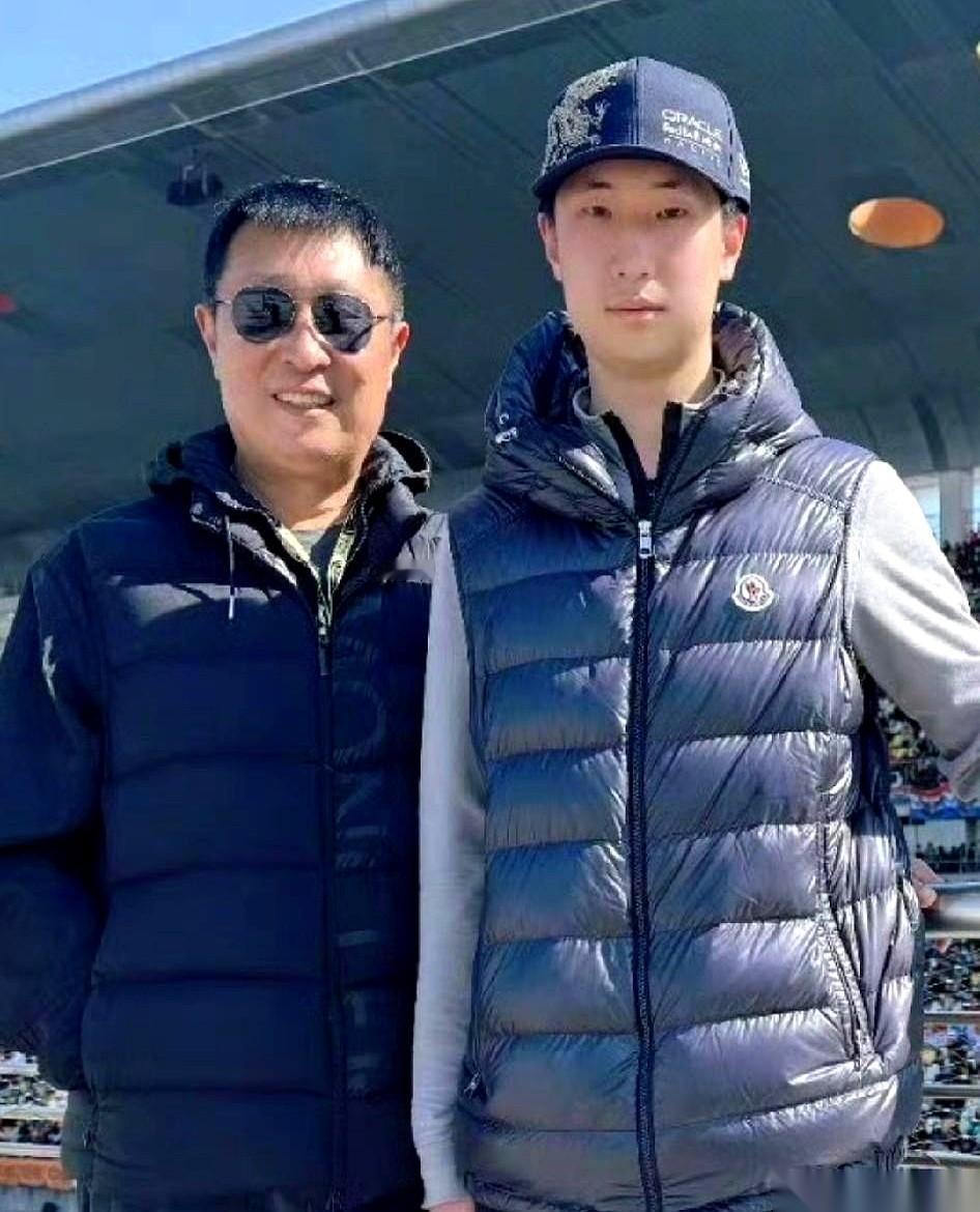 F1赛车引擎的轰鸣声里，镜头扫过林永健，所有人目光却被他身边那个少年吸走了。
比