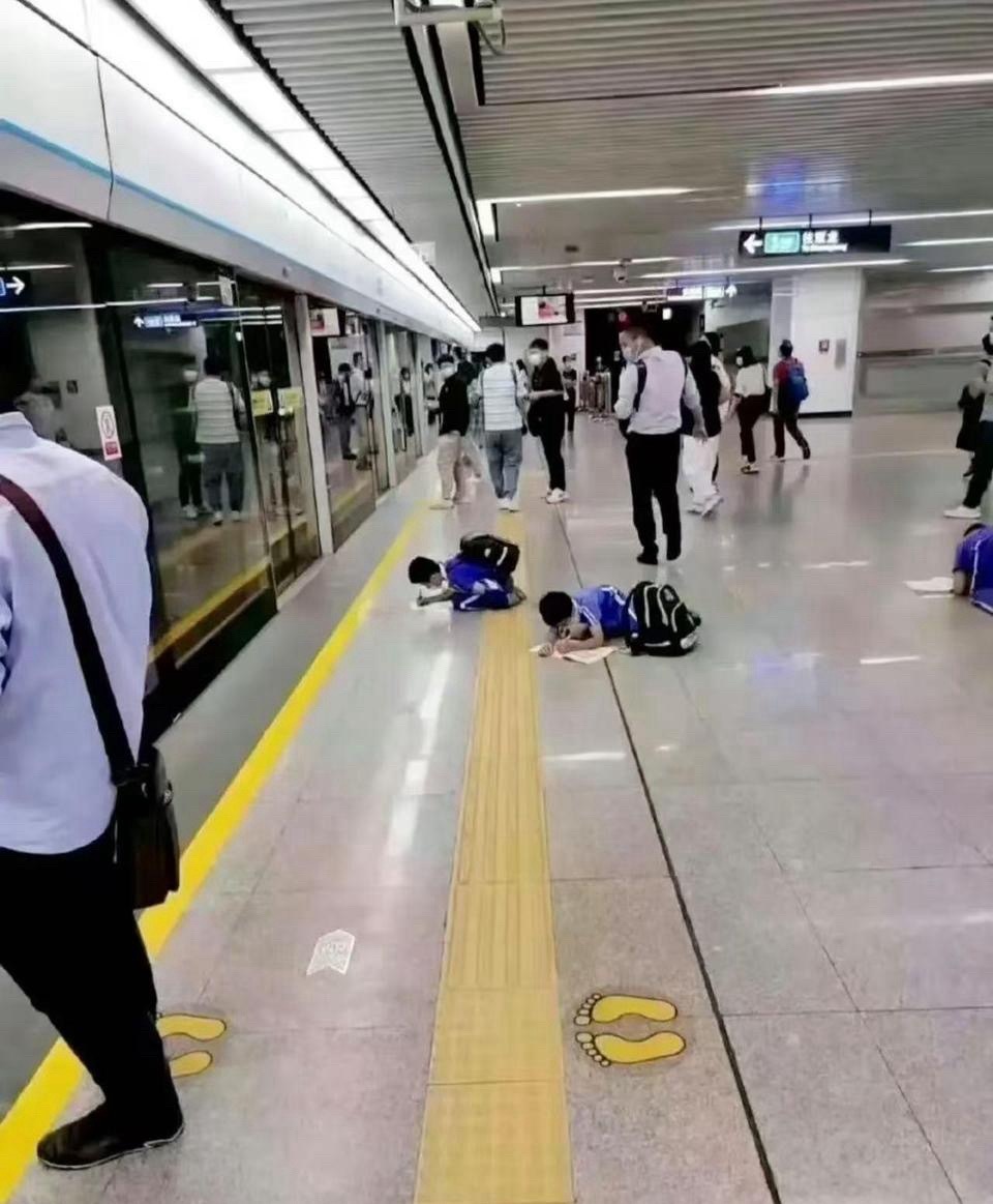 这就有点过于离谱了吧 看着也才小学那么大 学习压力这么大了吗？等地铁还要趴在地上
