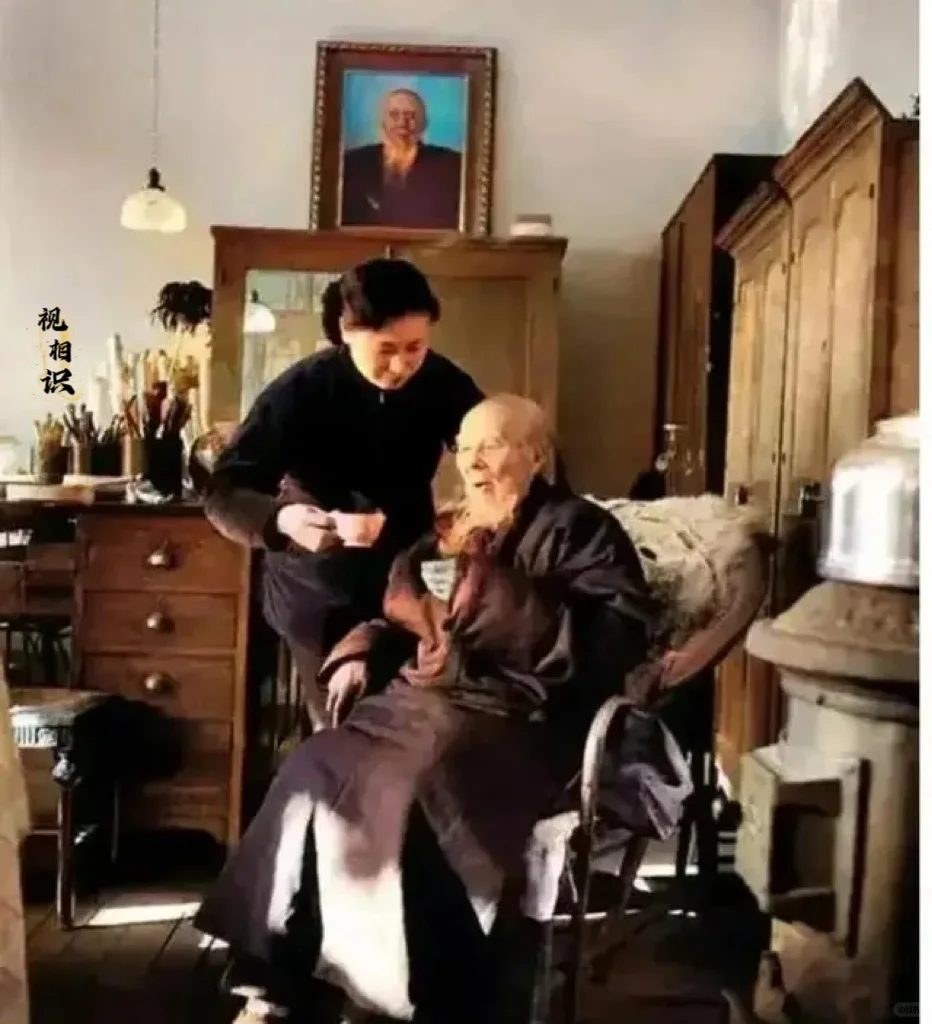 1957年，84岁的齐白石坐在椅子上正准备喝茶，在一旁侍奉他的是护士夏...