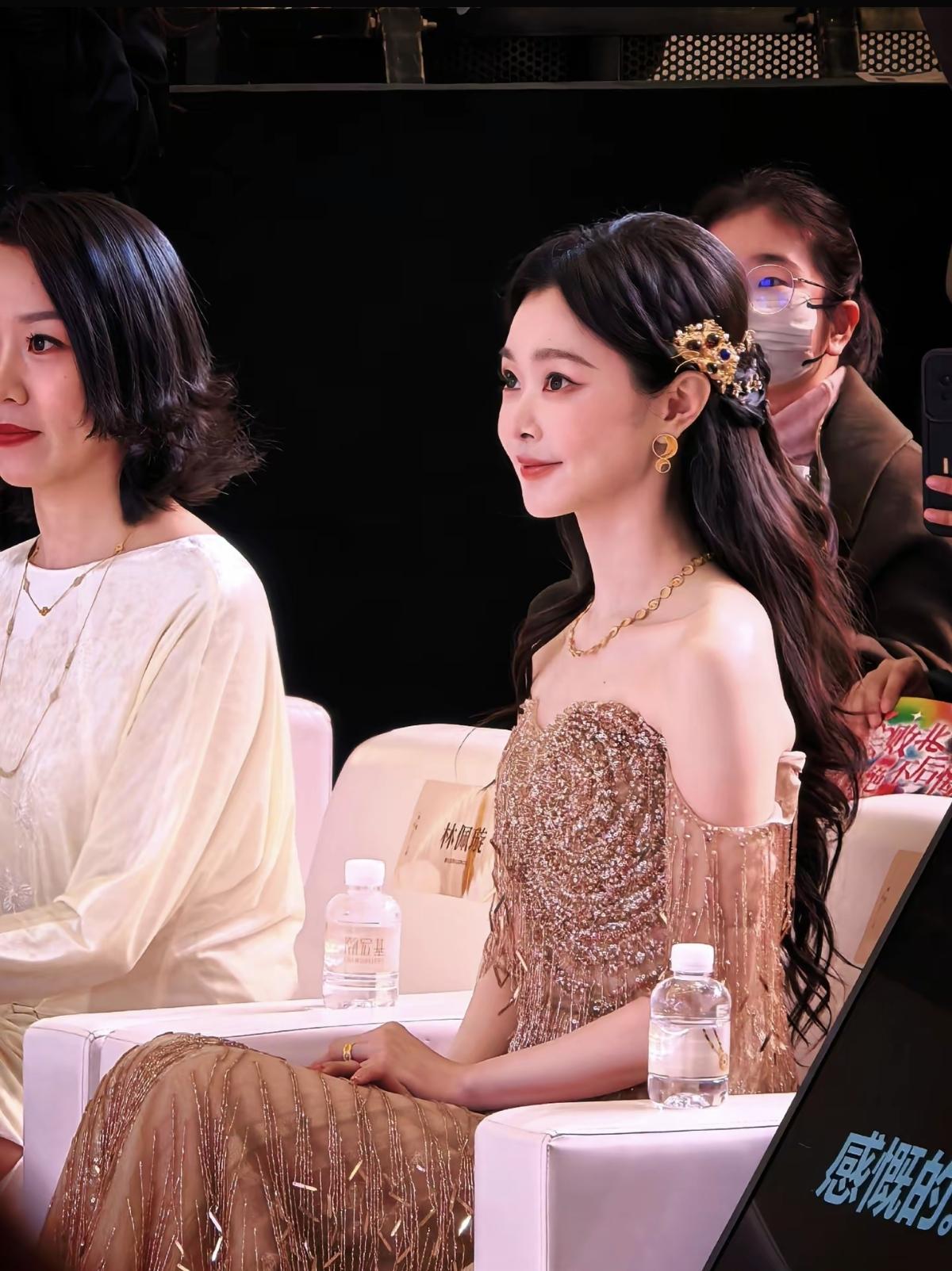 宋轶一袭鎏金礼服亮相活动，薄纱披肩衬得肩颈线条愈发精致，暖调碎钻在灯光下流动着光