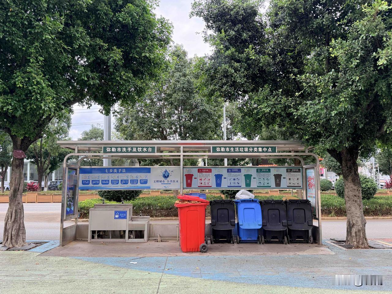 在弥勒老城区闲逛，时常能偶遇照片中这样的公共洗手亭。

街边树荫下，搭起简易的遮