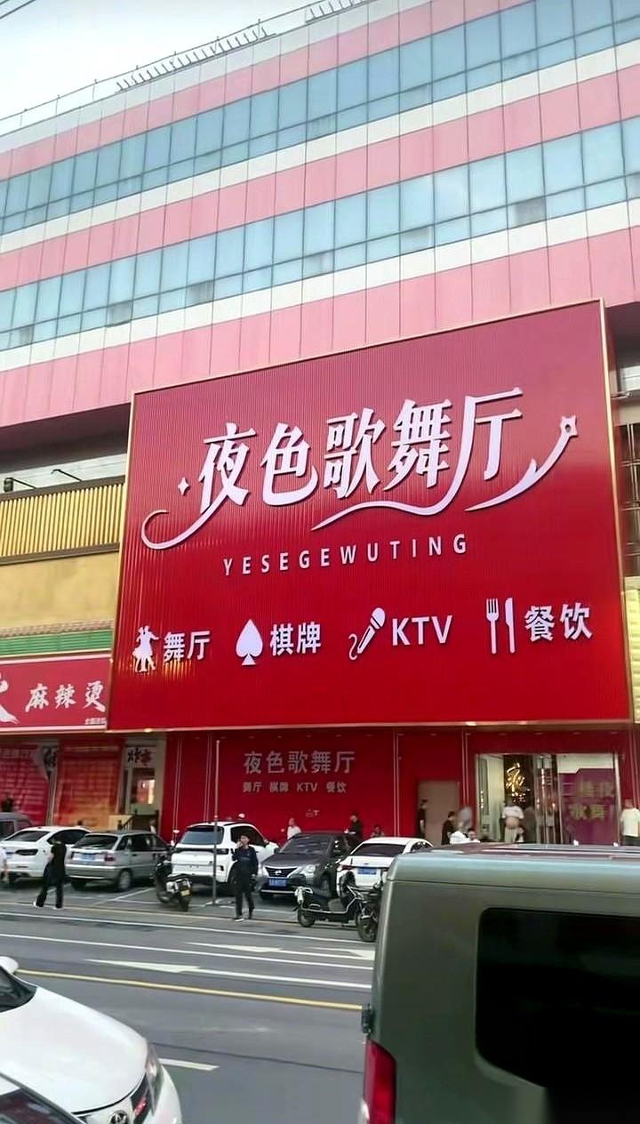 邻居大哥正搂着个女的在舞池里扭。旁边红黑相间的破沙发上，一个大姐嘬了半口烟，吐出