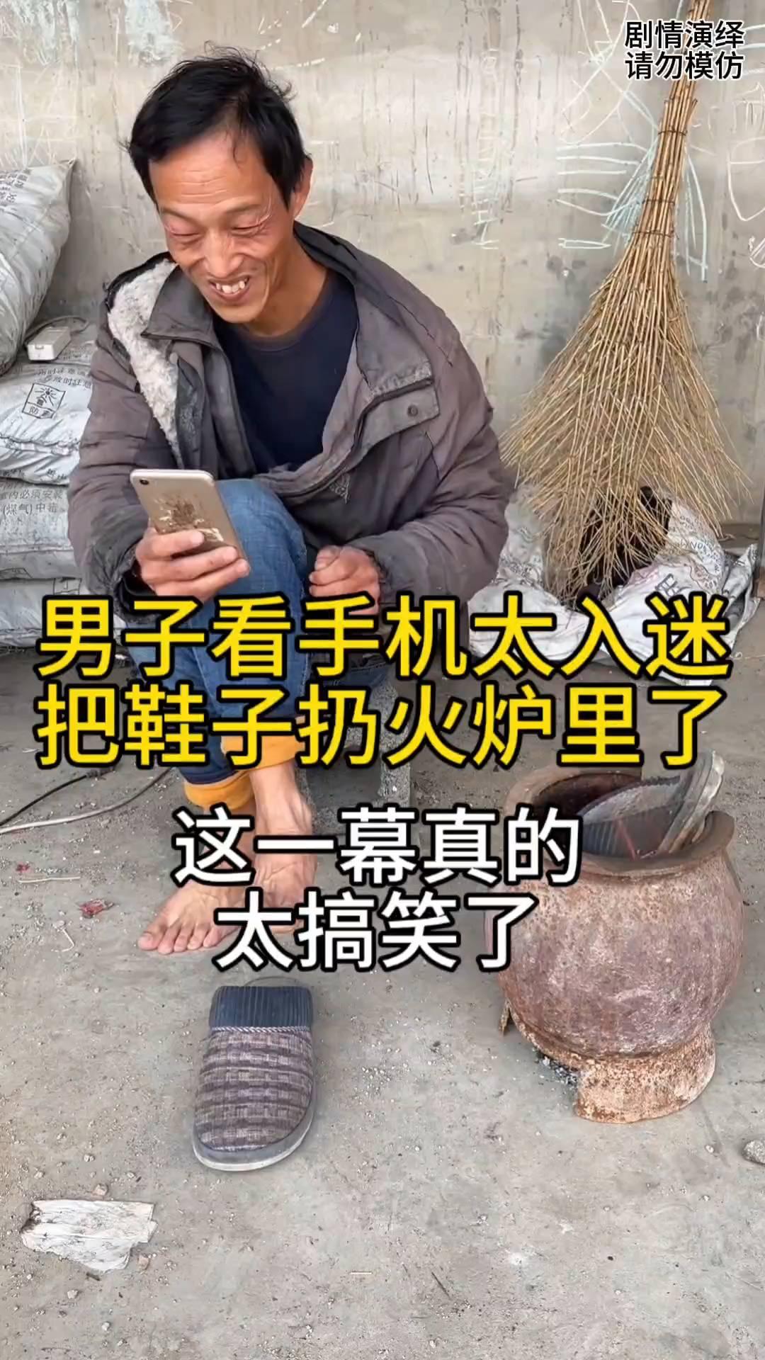 男子看手机太入迷，把鞋子扔火炉里了。
男子拿着手机看的很入迷，就当他烧火时把鞋子