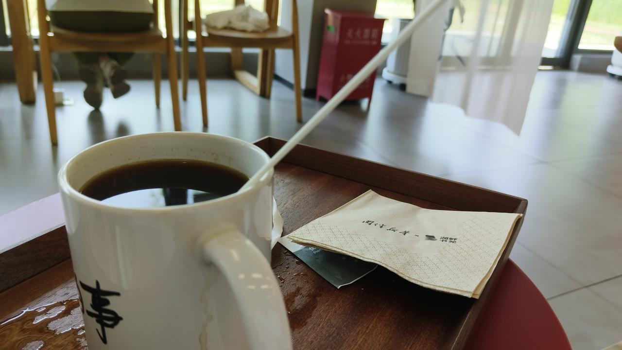 咖啡杯特写：聊城大学慢生活的仪式感

一杯黑咖啡静静放在木质托盘上，旁边是一张印