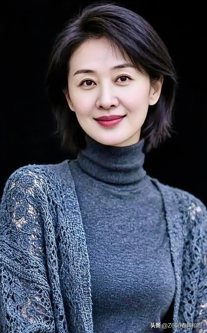 灰调针织温柔包裹，短发微扬。黑色背景前微笑凝视，从容淡雅，诠释岁月沉淀的静美风华