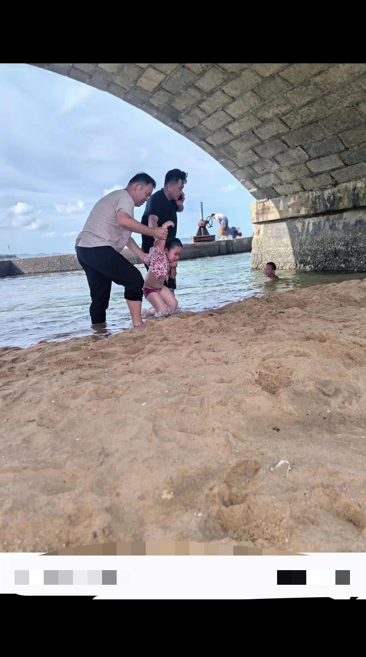 7月20号我们到威海玩，打电话的是我老公，小女孩被淹没，我老公一边打电话一把提起