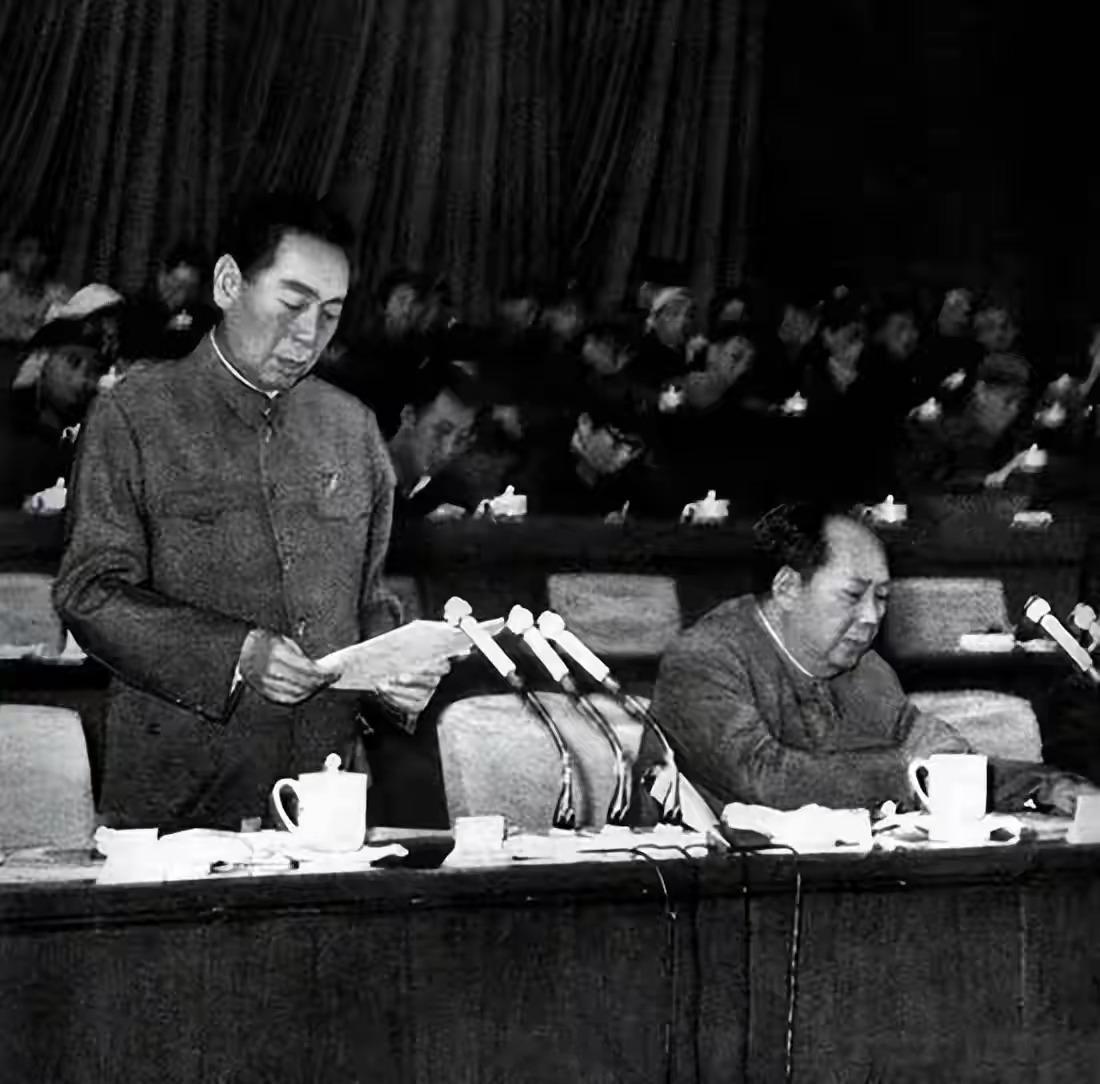 庄严的大会现场，周总理站立宣读文稿，神情郑重，毛主席端坐一旁凝神倾听。台下代表济