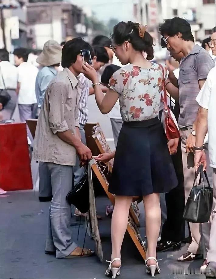 1985年的街头美女，图一美女手中是拿着手机吗？
如今四十年过去了，想必照片中的