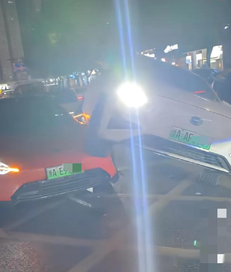 12月25日，圣诞节晚上，浙江杭州。白色传祺骑在了橘红色小米su7身上。围观群众