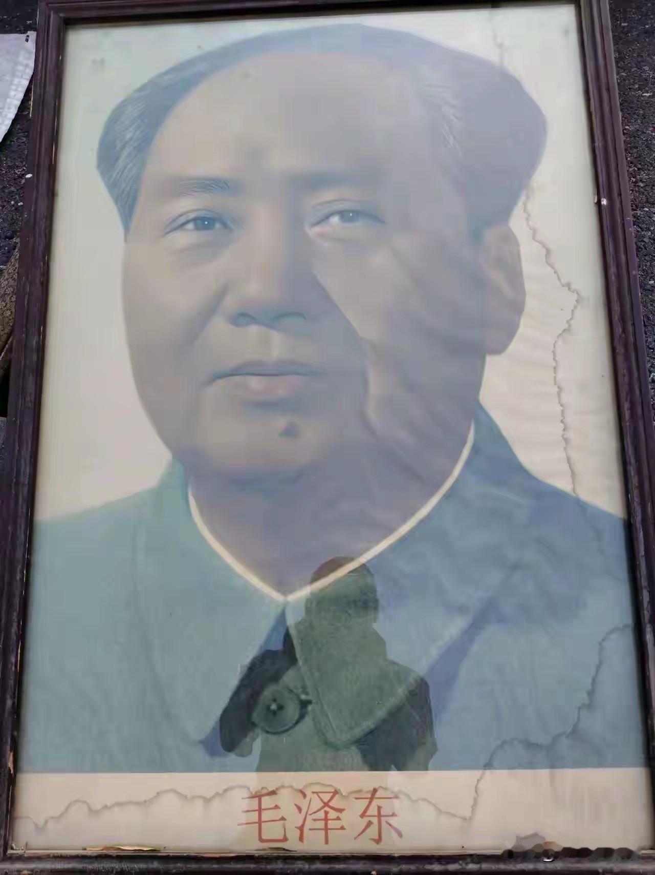 历经岁月的老式毛主席画像，木框斑驳，画面留有时光侵蚀的痕迹。熟悉的面容庄重大气，