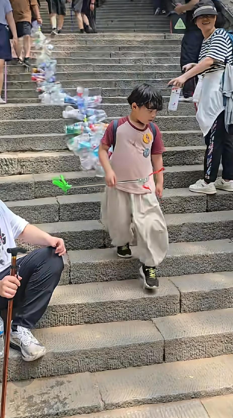 景区的石级山道上，一名小男孩拖着一长串空瓶子走过来时，游客的眼里都是满满的惊讶和