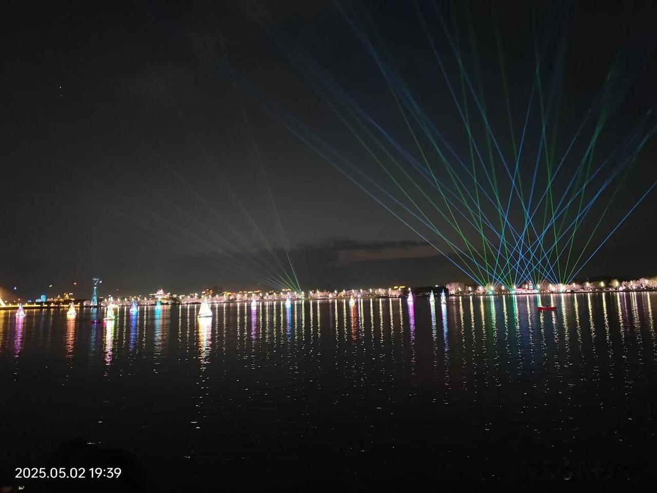 哈尔滨沿江公园没有中央大道那么多游客，夜晚的松花江里还有单人音乐帆船表演，市民和