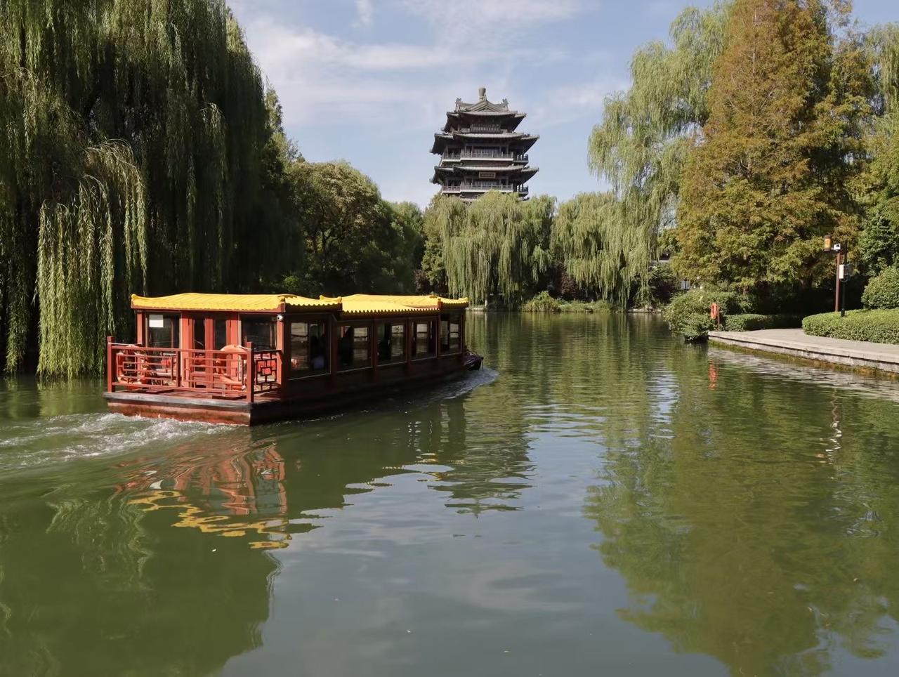《泛舟图》

泉水一脉抱翠流，
画舫金檐照水悠。
两岸风摇千树绿，
船载秋光慢慢
