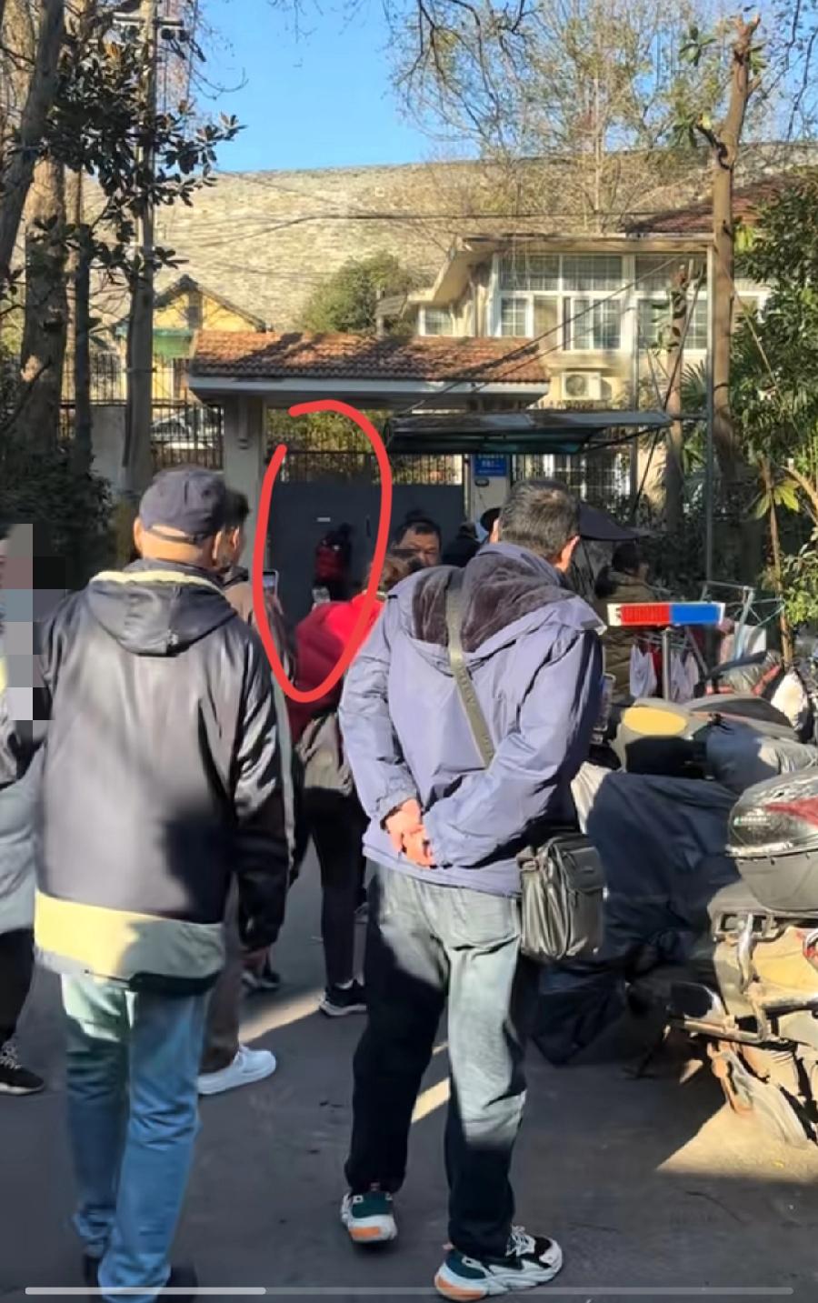 徐湖平的家门口，现在真热闹，一波一波的围观群众，两个人还趴在大门上，透过门缝往里