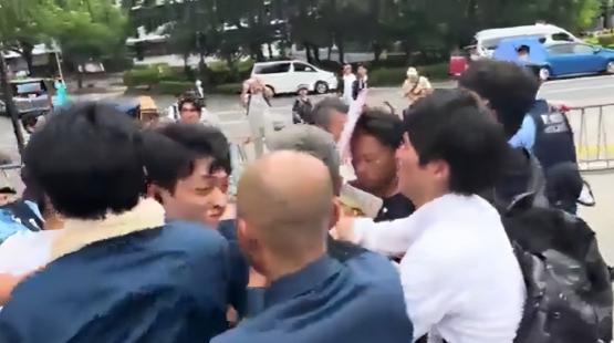 活该！一名精日台湾男子举着"我欢迎日本再次侵华"的牌子，头上还披着乌克兰国旗，像
