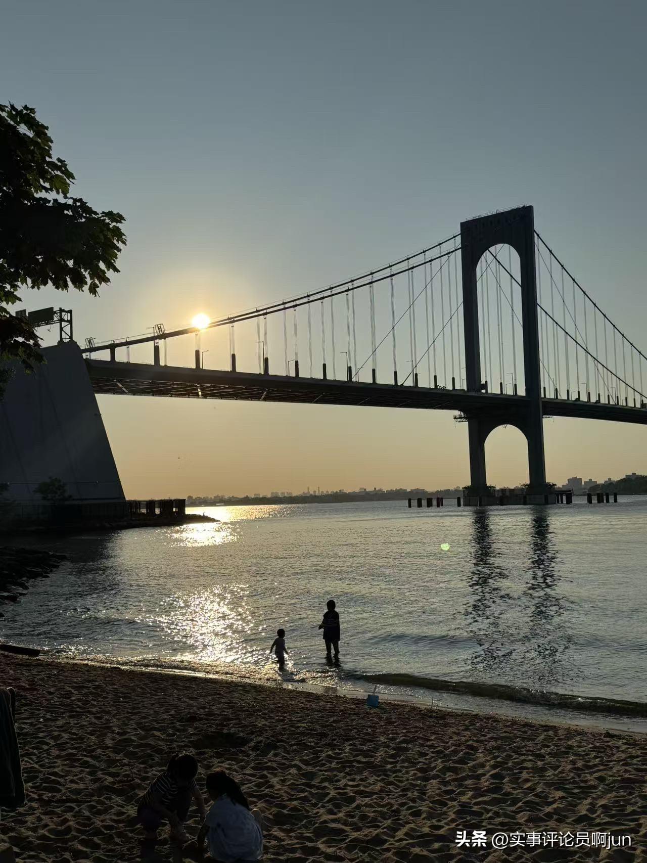 落日沉光挂远桥，
清波不语绕沙滩。
稚子踏浪留欢影，
半是人间半梦闲。