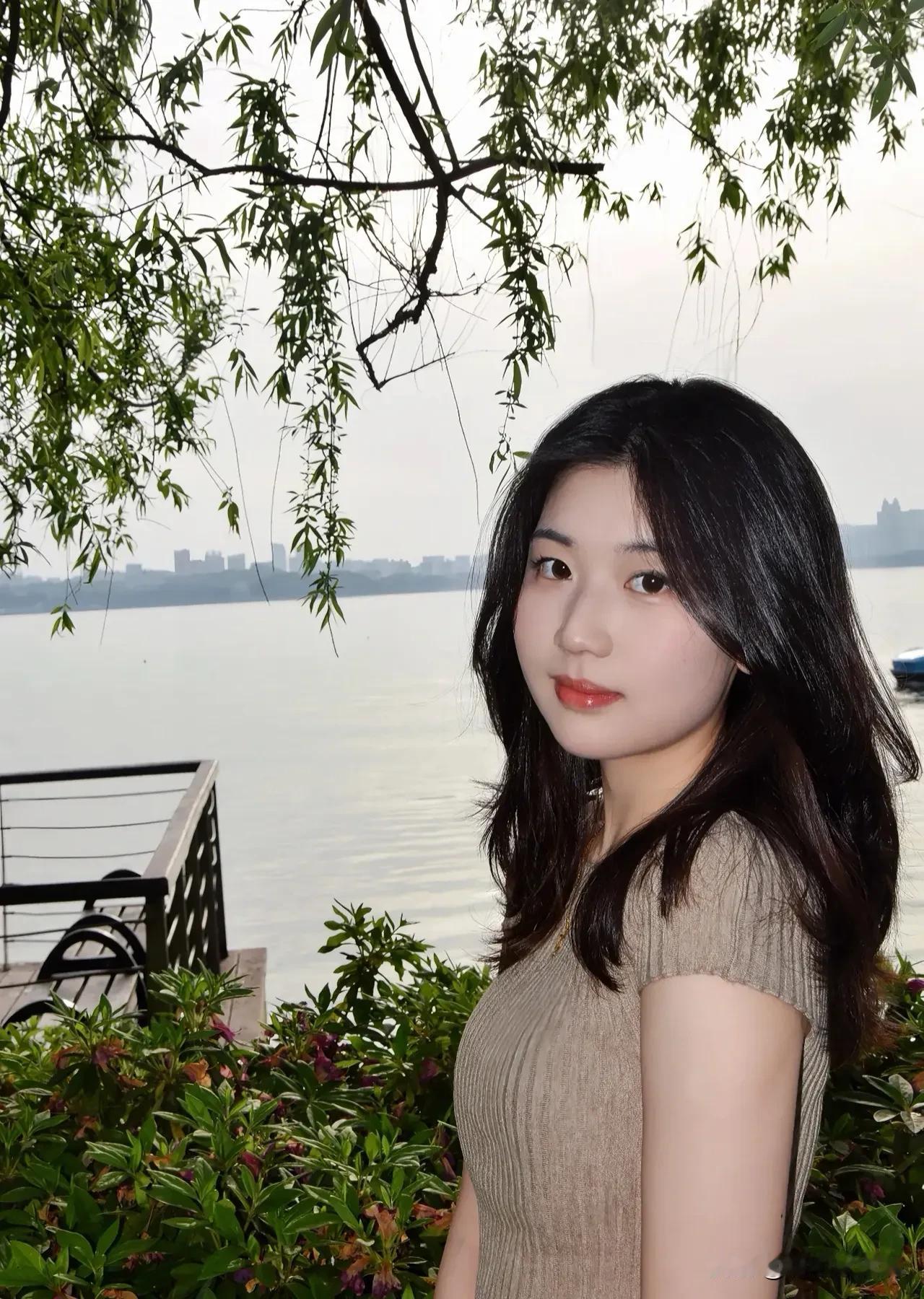 清晨微风拂过湖面，
她静静伫立，裙角轻扬，
如画中走来的仙子。
优雅从容，气质非
