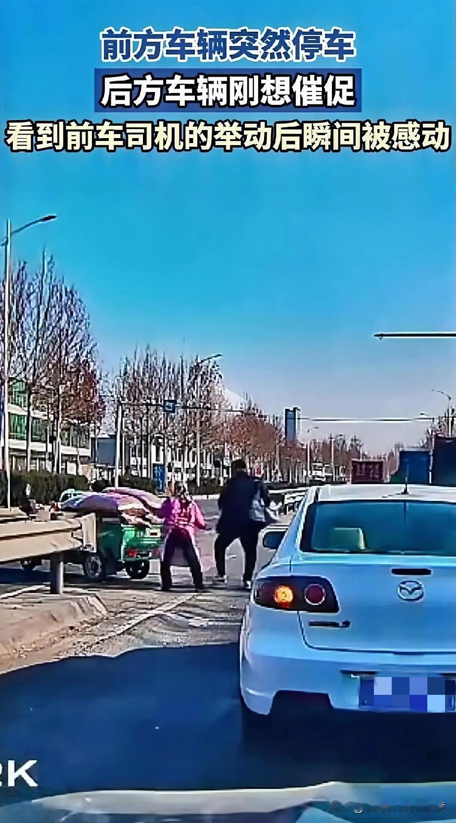 让人感动！一辆车正常行驶中突然停车
，司机随后打开车门出来，跟后车打了一个招呼后