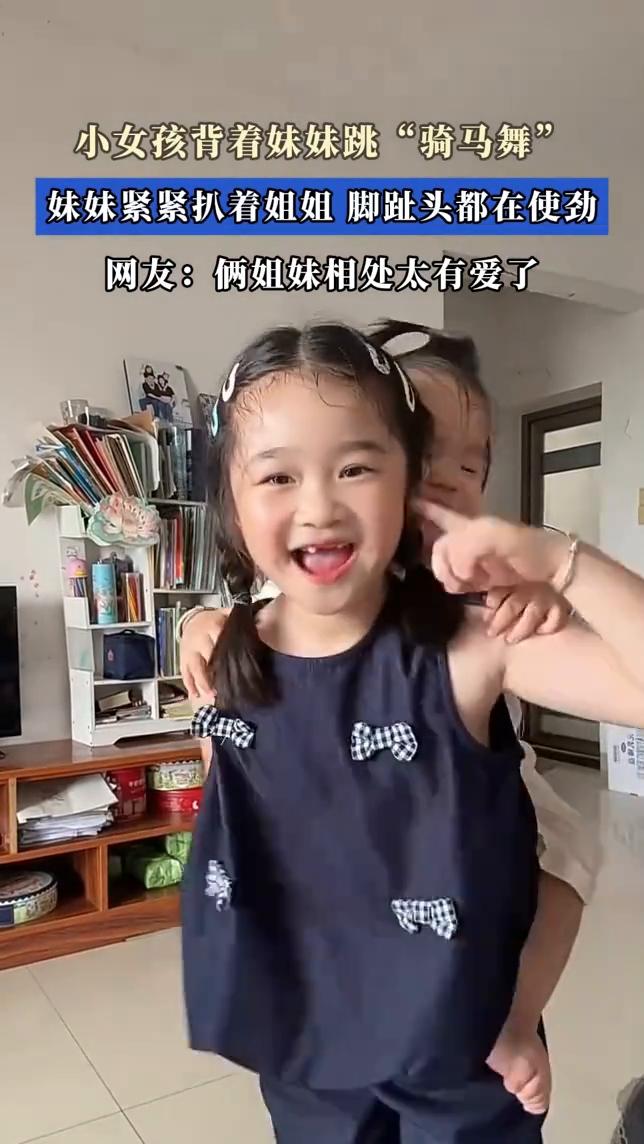小女孩背着妹妹跳"骑马舞"，妹妹紧紧扒着姐姐脚趾头都在使劲。
网友：俩姐妹相处太