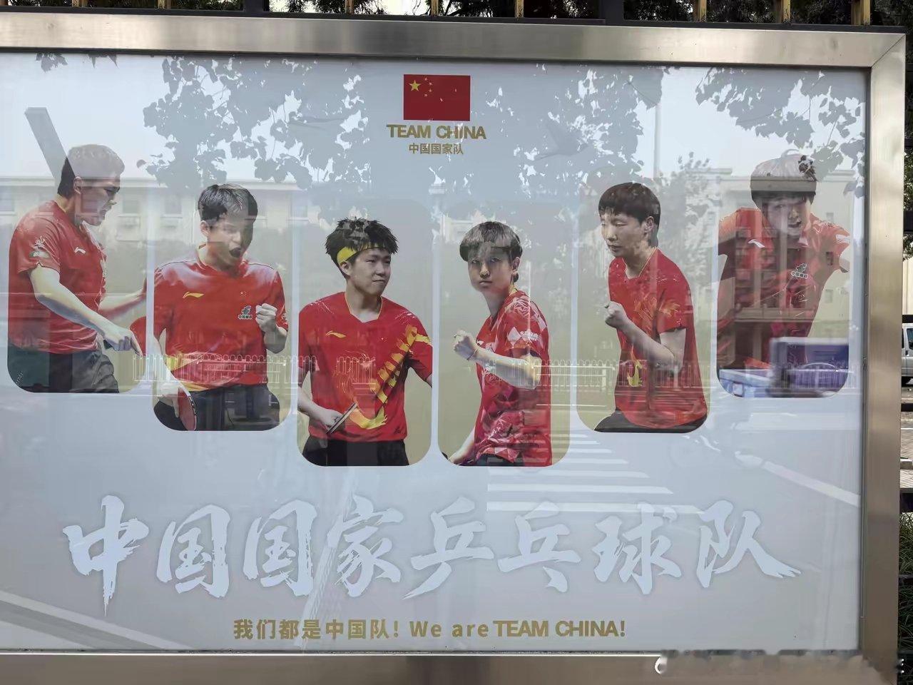 体育馆的海报换新啦！一身中国红，孙颖莎、王楚钦、林诗栋六位队员，全都是洛杉矶奥运