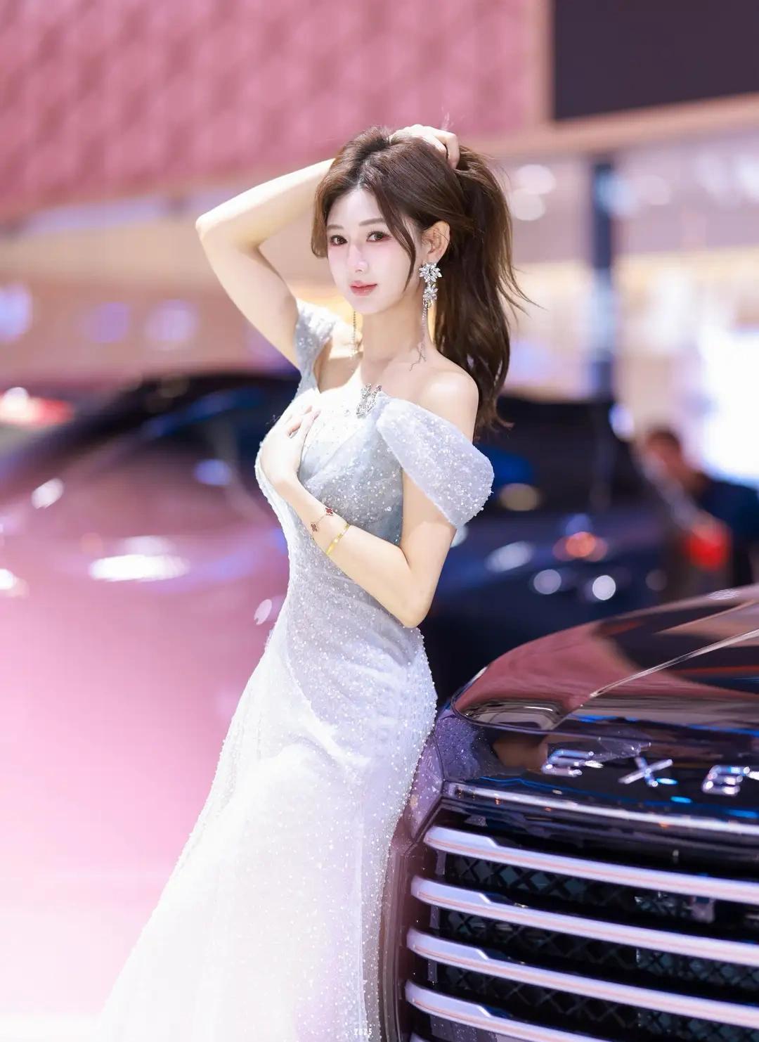 银色吊带裙在聚光灯下流淌着液态金属般的光泽，我站在流线型跑车前，指尖刚触到冰凉的