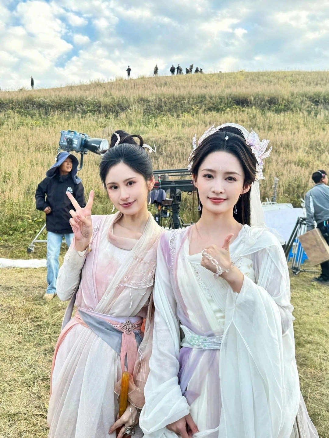 李沁 片场同框也太仙了吧！李沁一袭白紫渐变仙裙，搭配精致头饰，温婉大气；身旁的伙