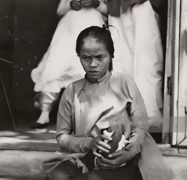 1969年，一个越南女子掀起上衣，一边小心翼翼地给一条狗喂奶，一边心疼自己还在饿