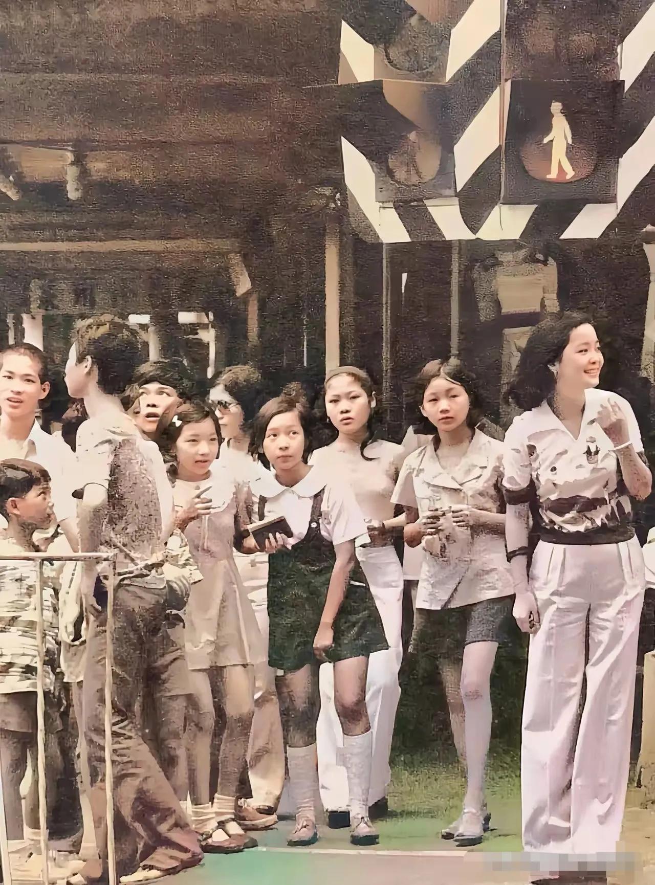这是邓丽君青春少女时，和一群小学生在一起，像不像小学生们的老师？带领孩子过马路。