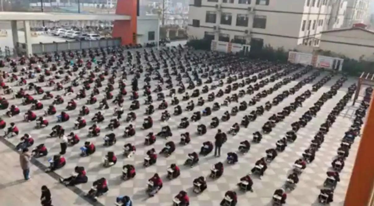 12月18日，河南周口淮阳区翰林高级中学让数百高二学生在广场趴凳答题一事引发热议