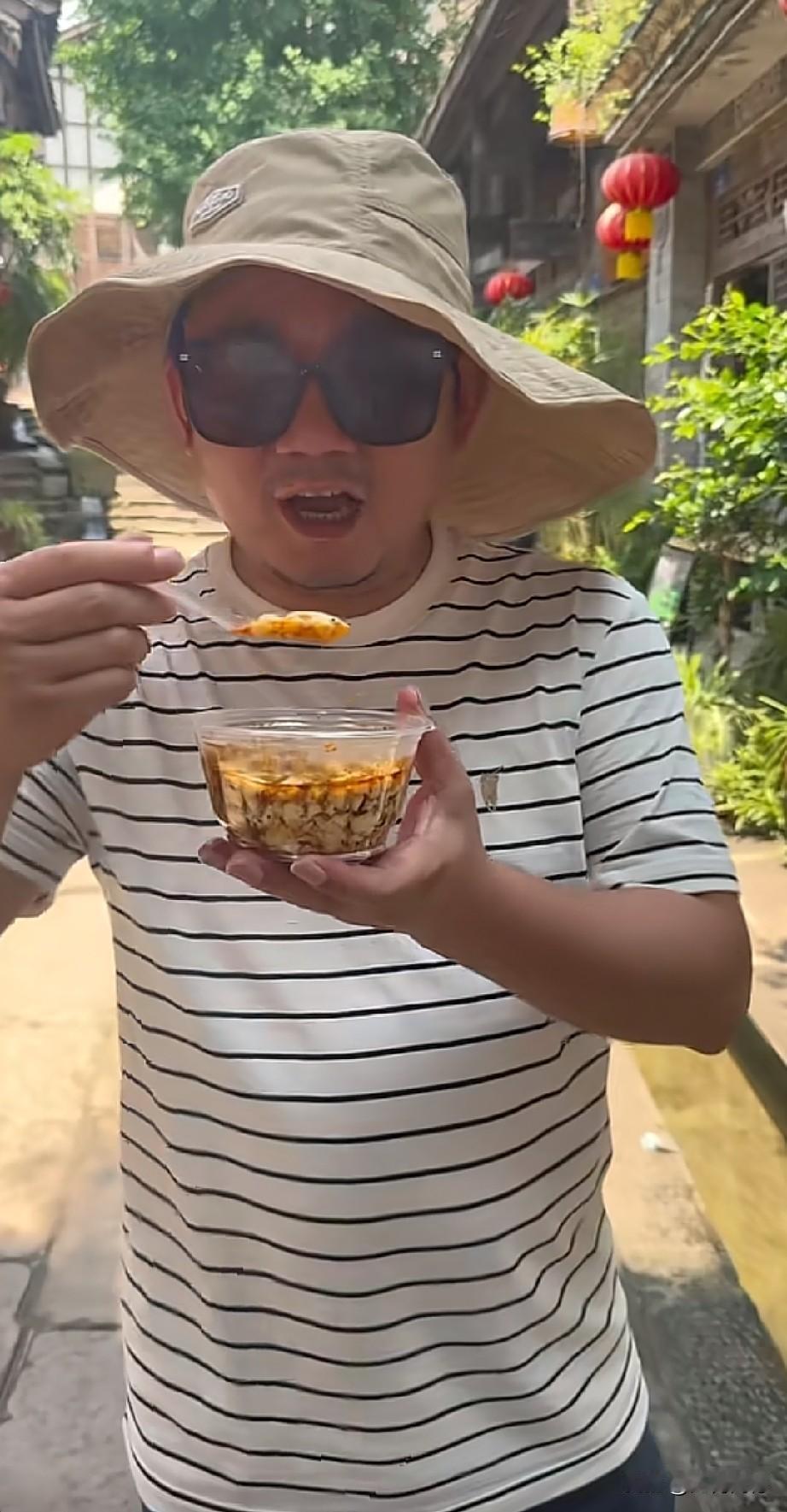 张雪这身儿休闲打扮，不细看的话，真看不出来是他，他这是到安居古城看龙舟，吃起了当