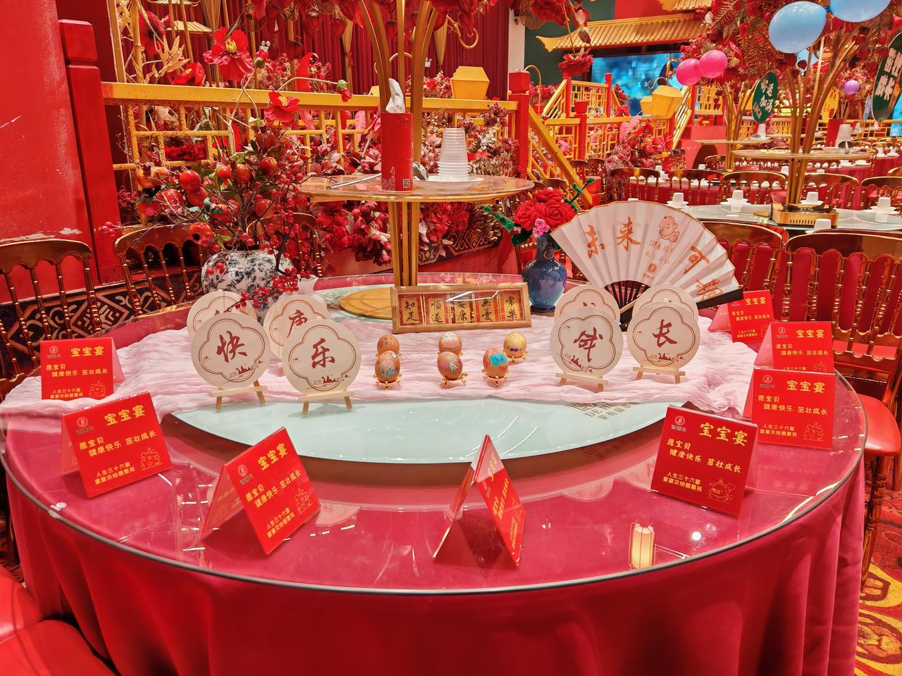 这桌宝宝宴也太有氛围感了吧！一进门就被这满桌的红给暖到了，桌布是透亮的红，椅子也