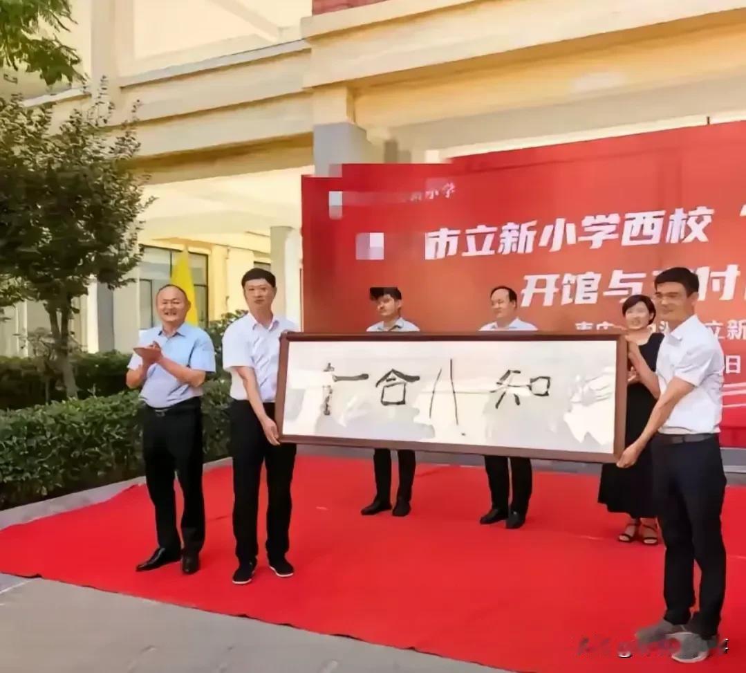 就这样写着“一合八知”一副书法作品挂在我家里我都嫌寒碜。
某市立新小学开馆，书法