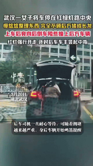武汉，一女子将车停在红绿灯路中央，下车慢悠悠整理东西，完全不顾后方堵成长龙，上车