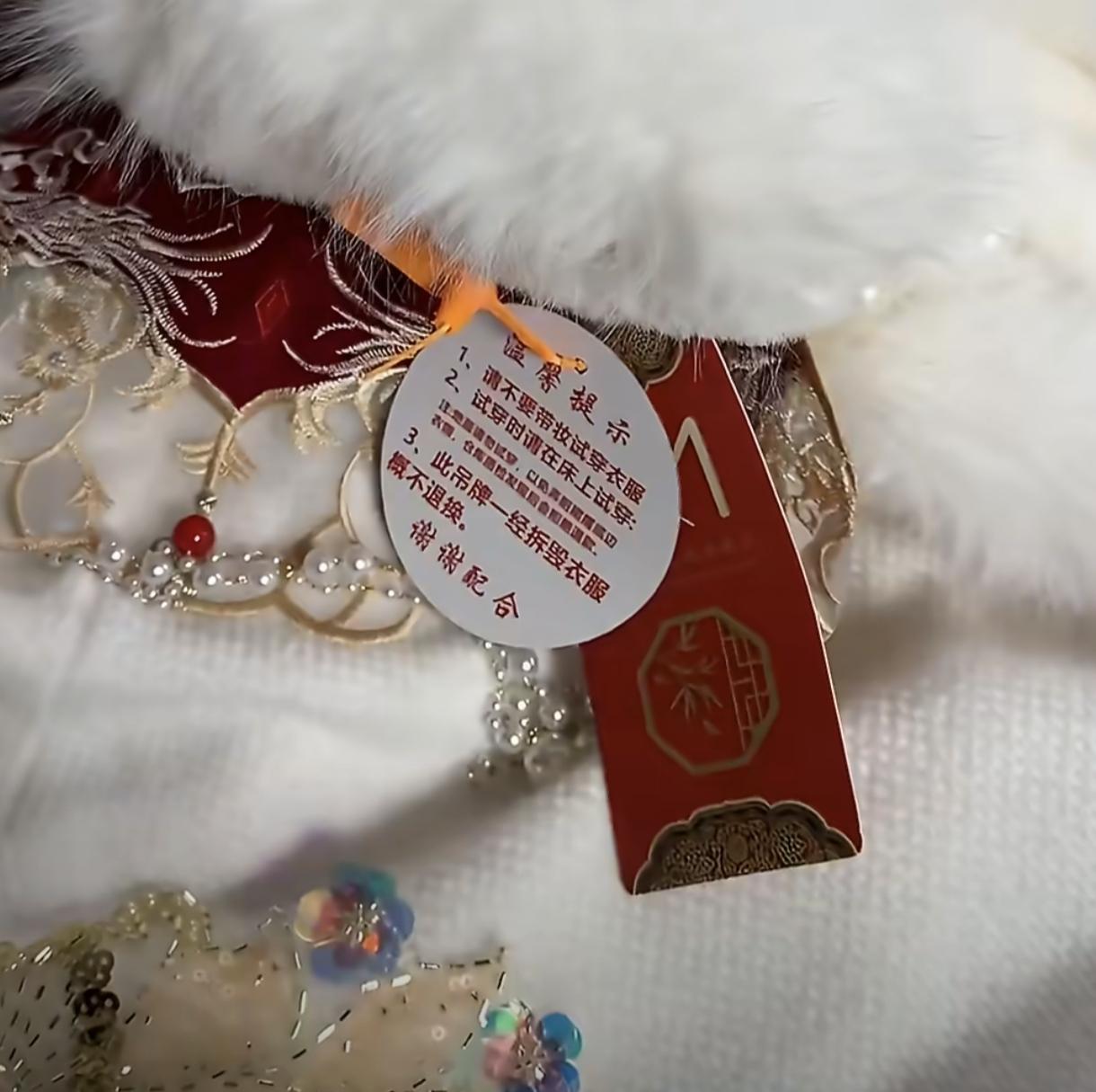 真的是“太聪明了”，
女子买婚服，
为了不让吊牌漏出来，用红色别针固定在领口位置