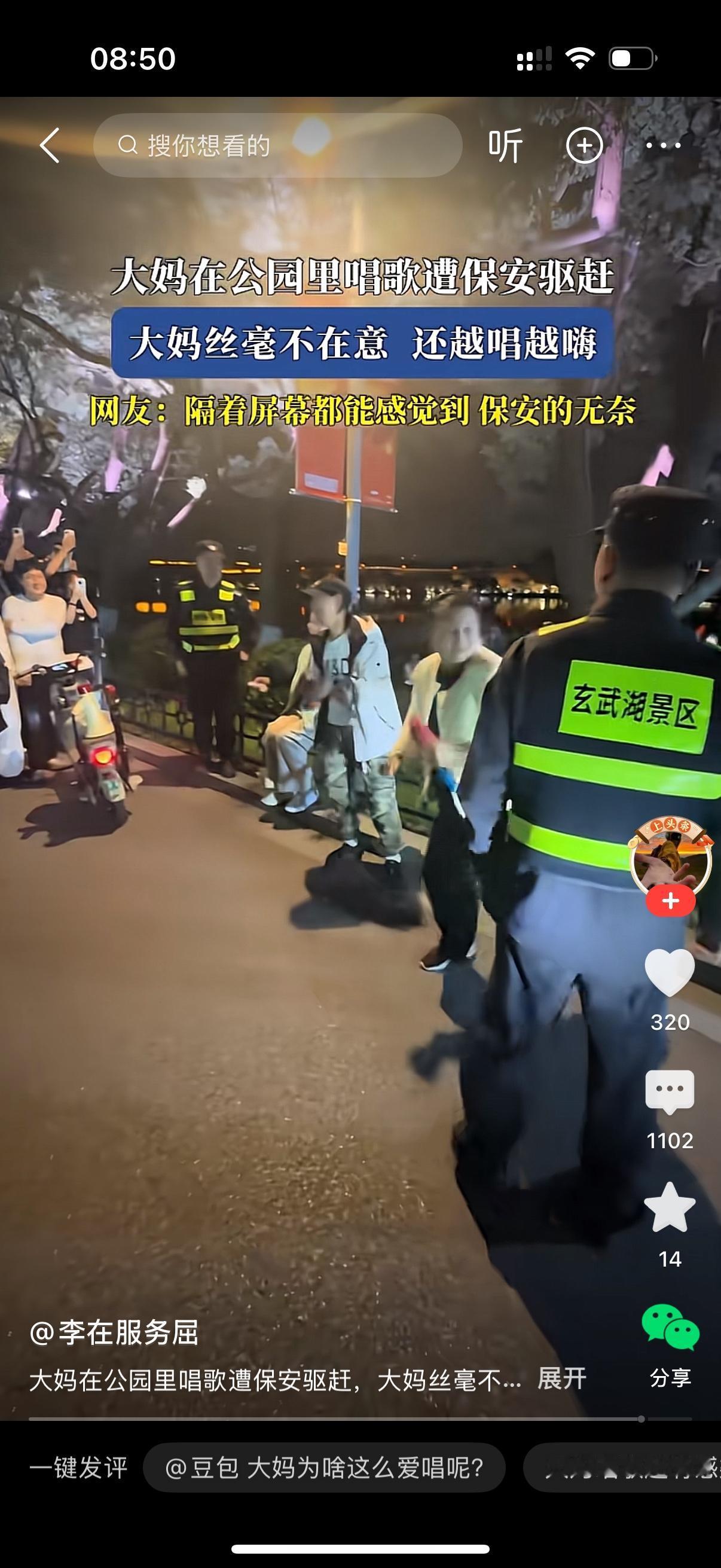 晚上的玄武湖景区，一群人正围着看热闹。一位大妈拿着麦克风，在路边放声高歌。几名玄